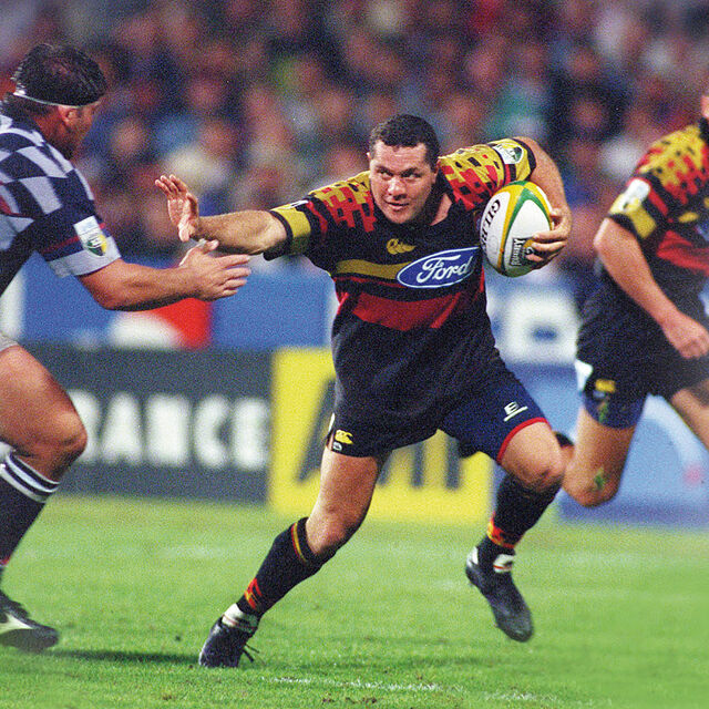 Chiefs player fends off an opponent while attacking the defensive line.