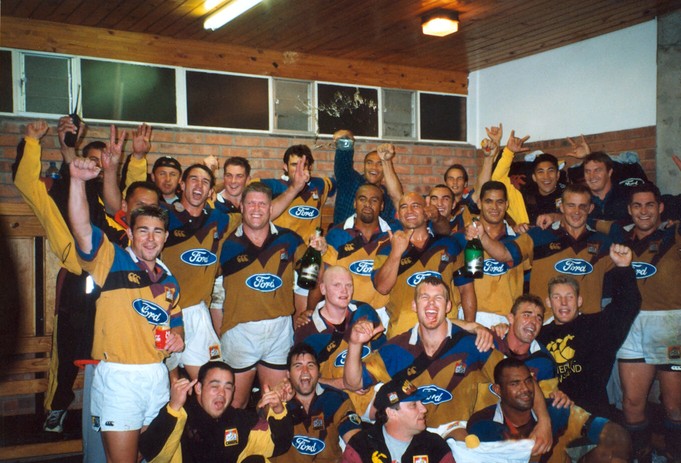 Chiefs team celebrates in the changing room after a memorable Super Rugby win, showing unity and pride in the jersey.