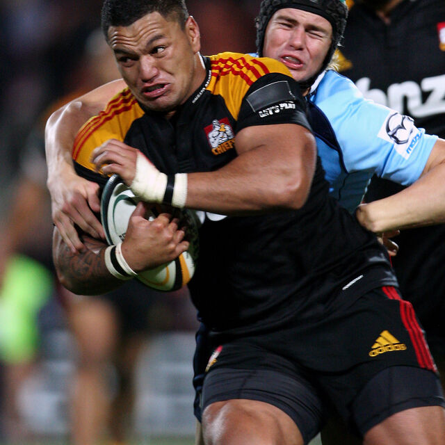 Chiefs centre powers through a defender’s tackle, showing physical dominance.