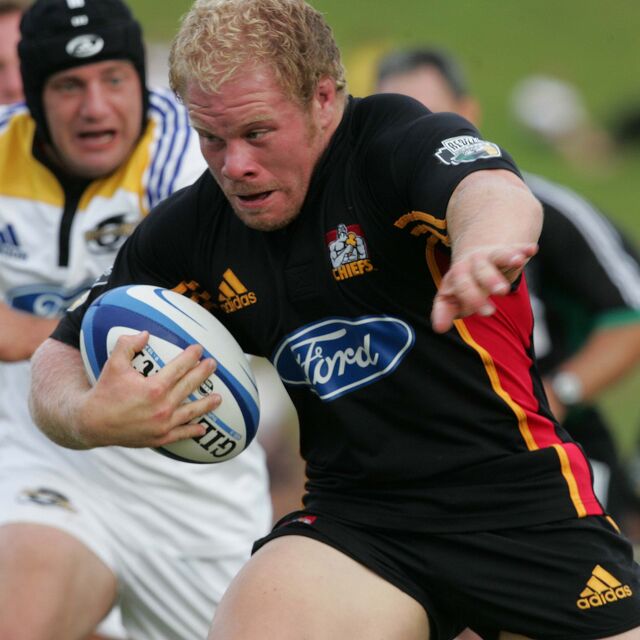 Chiefs forward charges forward with the ball, evading defenders with strength.