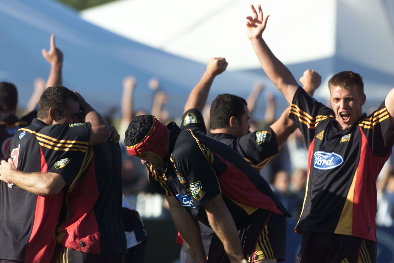 Chiefs players celebrate a hard-fought win with arms raised in triumph.