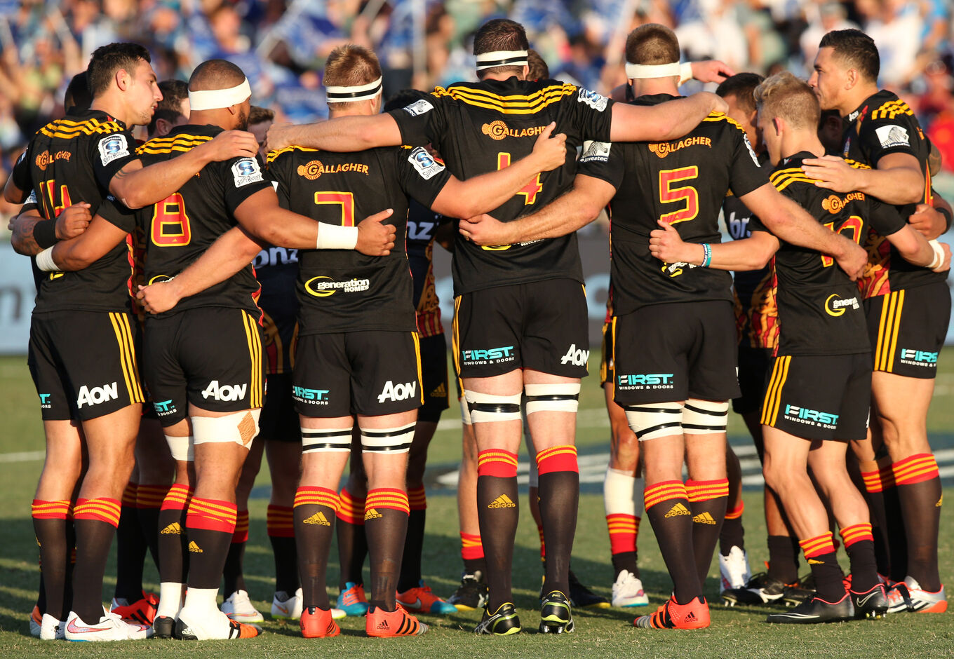 Chiefs players huddle on the field before kick-off, showing unity and focus as they prepare for the match.