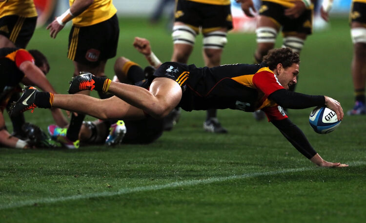 Chiefs player dives to score a try, showing determination and precision near the goal line.